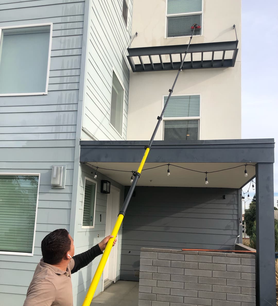 Man cleaning a third story window