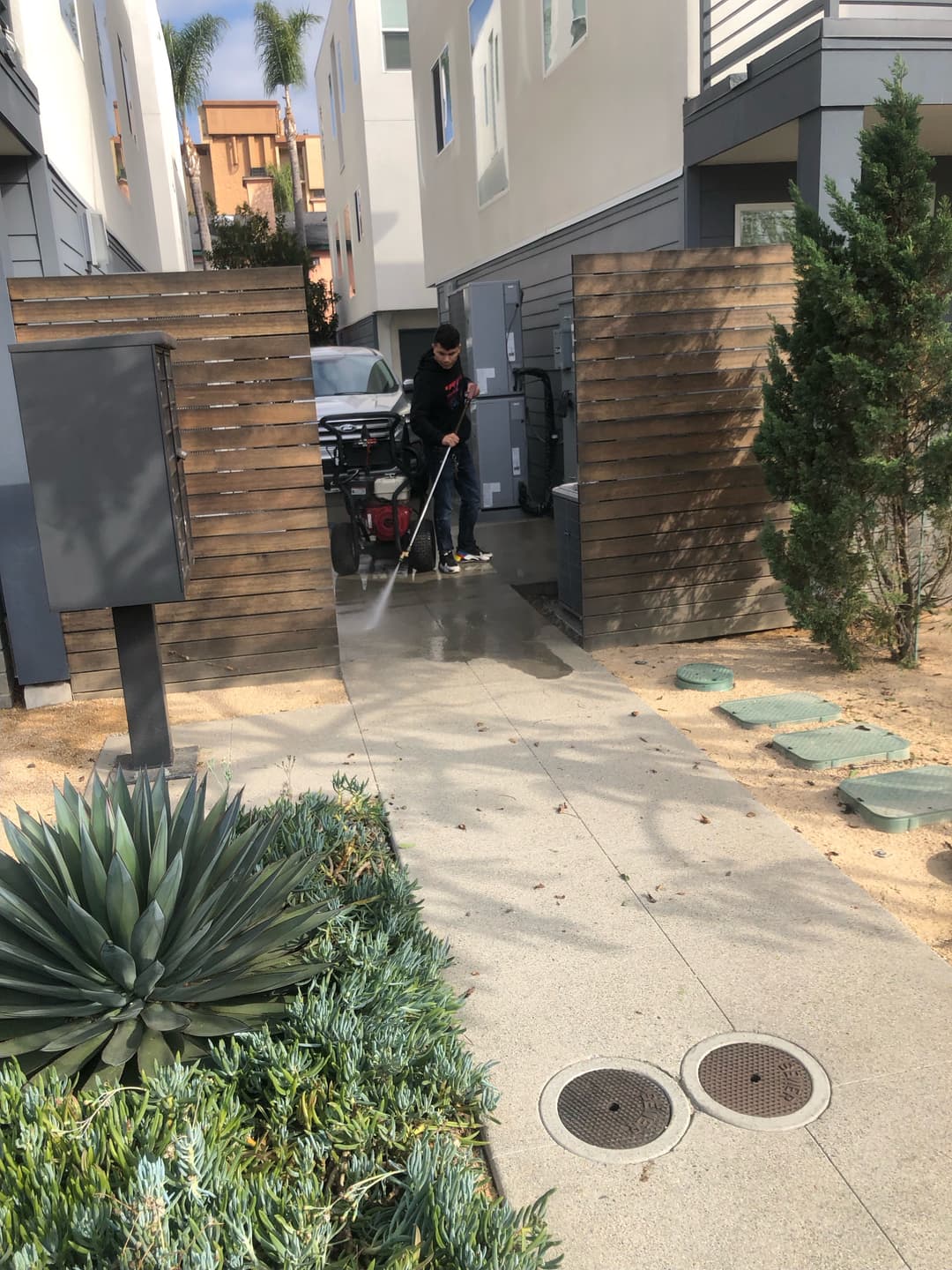 Man pressure washing a concrete driveway