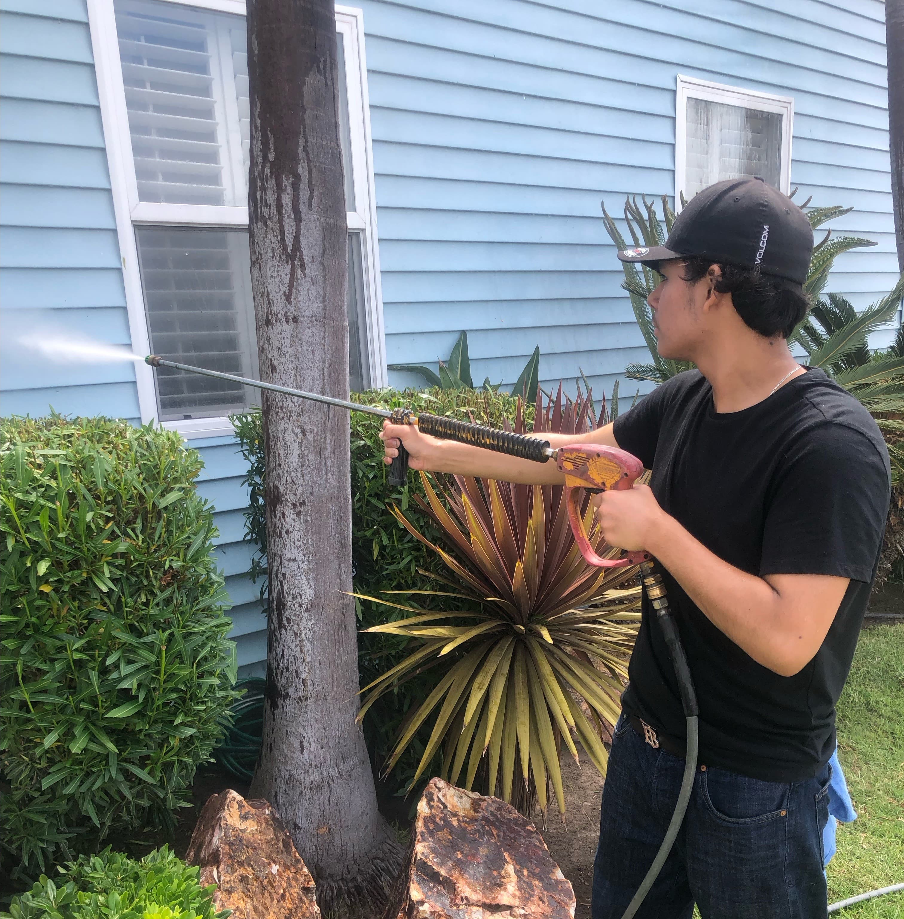 Man pressure washing siding